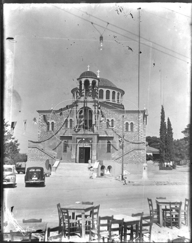 ΑΠΟΨΕΙΣ - Πειραιάς ΠΕΙΡΑΙΑΣ. ΑΠΟΨΗ ΤΟΥ ΝΑΟΥ ΤΟΥ ΑΓΙΟΥ ΣΠΥΡΙΔΩΝΑ. ΔΙΑΚΡΙΝΟΝΤΑΙ ΔΥΟ ΣΤΑΘΜΕΥΜΕΝΑ ΑΥΤΟΚΙΝΗΤΑ ΚΑΙ ΤΑ ΤΡΑΠΕΖΑΚΙΑ ΑΠΟ TO ΥΠΑΙΘΡΙΟ ΚΑΦΕΝΕΙΟ ΑΠΕΝΑΝΤΙ. Σάββατο, 26 Ιουλίου 1952.jpg